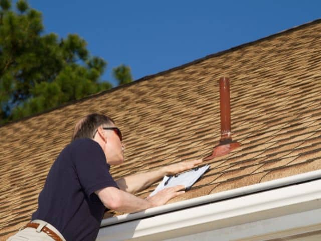 adjuster performs roof inspection
