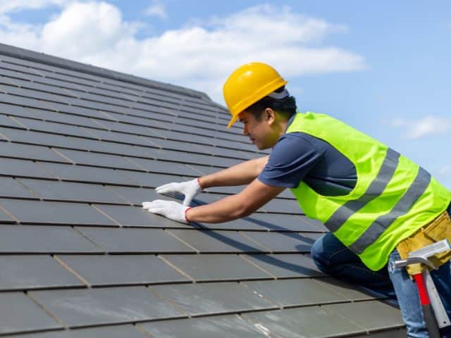 contractor installs roofing tiles