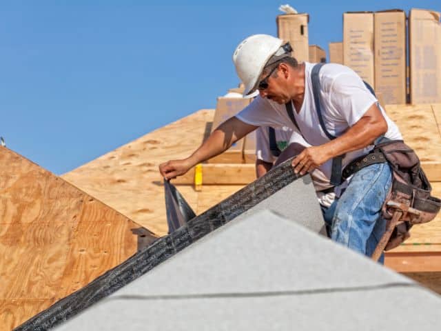 contractors installs underlayment to roof decking